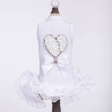 The image displays the Hello Doggie Endless Love Dog Dress, featuring a white dress with a heart-shaped floral design and a bow on the back, along with lace trim at the bottom