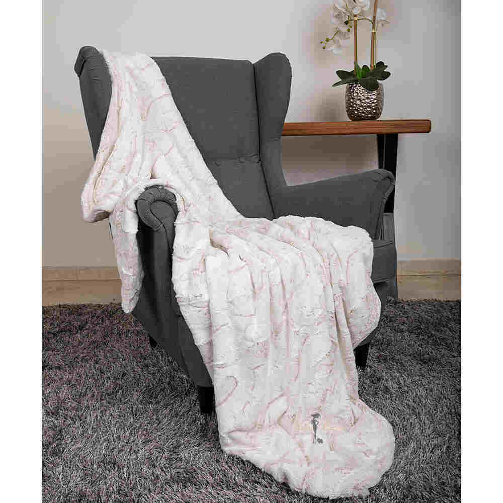 The image features the Hello Doggie Whisper Dog Blanket in baby pink color, elegantly displayed on a gray armchair next to a small table with a potted plant