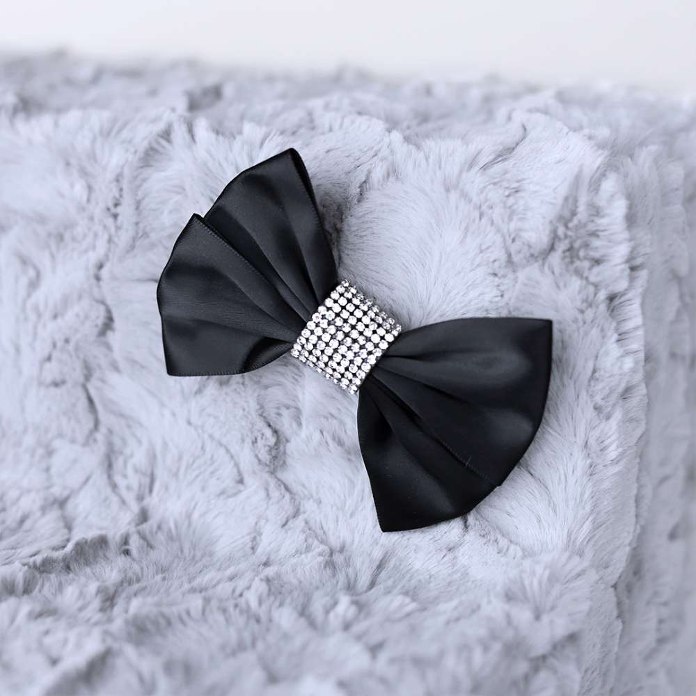 The image is a close-up of a bow decoration on the gray Hello Doggie Luxury Pet Stairs, featuring a black ribbon and rhinestone center