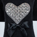 The image shows a close-up of the Hello Doggie Oh My Heart Dog Sweater, featuring a sparkling heart design with a bow on a black knit fabric