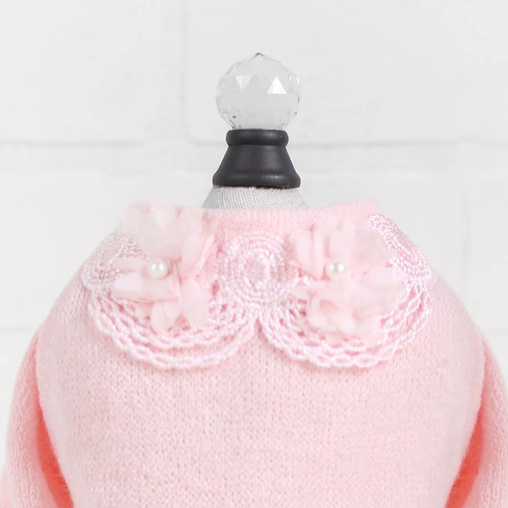 The image shows a detailed view of the collar on the Hello Doggie Sweet Magnolia Dog Sweater in pink, adorned with delicate lace and floral accents