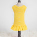 The image shows a yellow Hello Doggie Candy Dog Dress on a mannequin with small decorative bows down the back and a ruffled hem