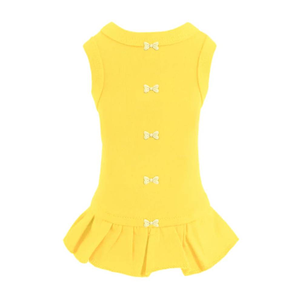 The image shows a yellow Hello Doggie Candy Dog Dress with small decorative bows down the back and a ruffled hem