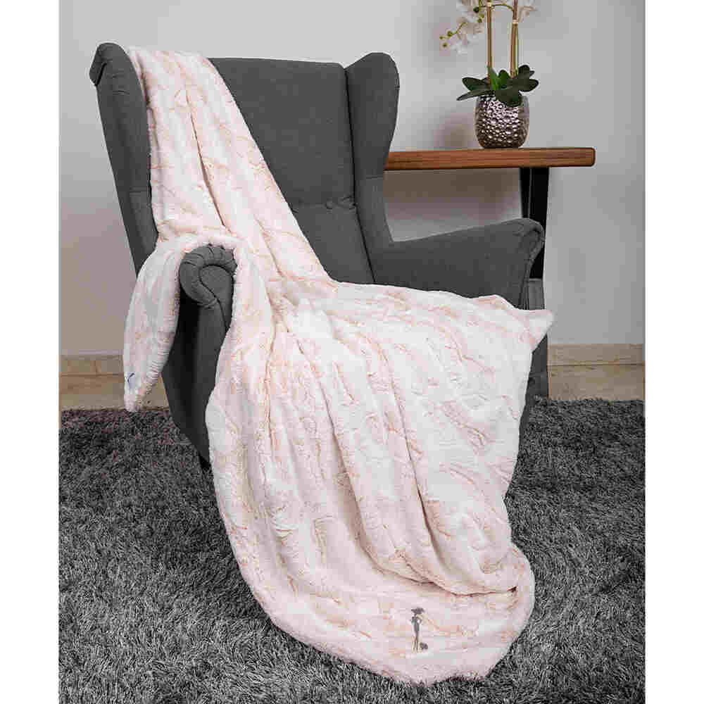 The image shows the Hello Doggie Whisper Dog Blanket in peach color, displayed on a gray armchair, enhancing the room's decor with its gentle hue