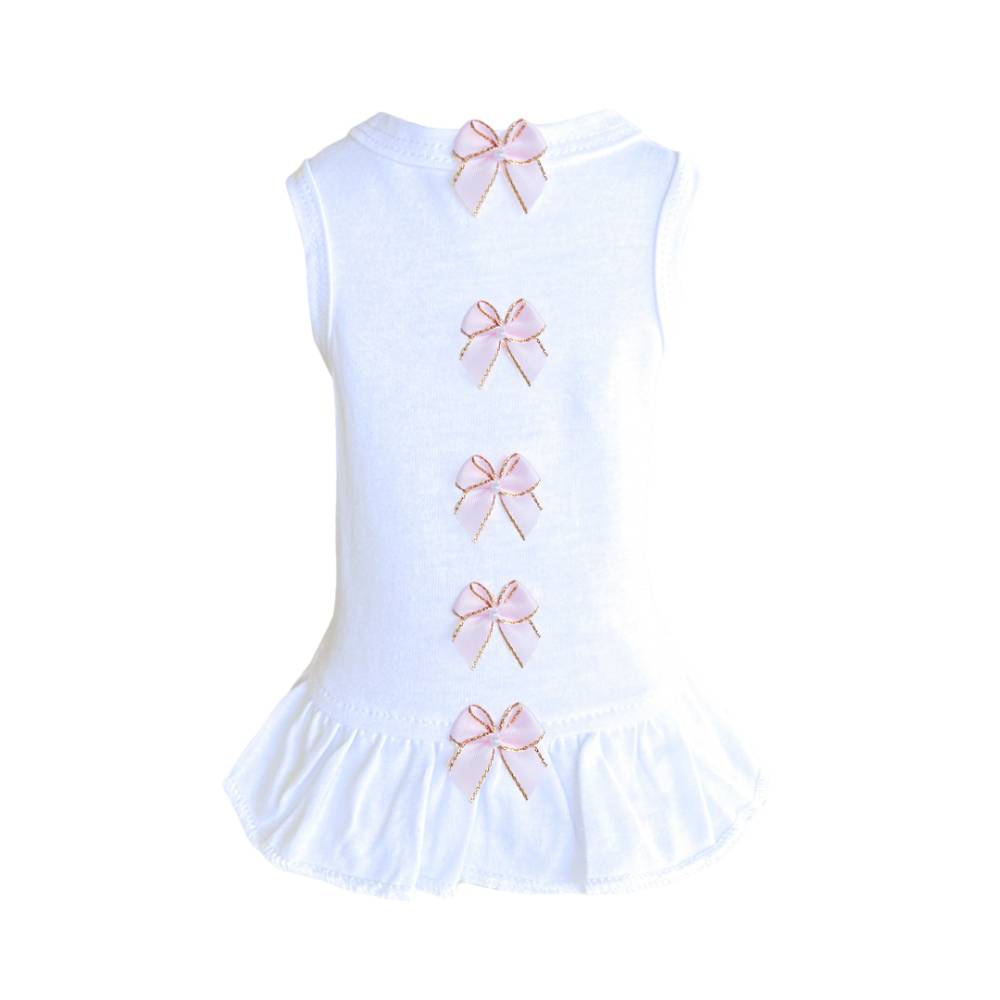The image shows the back of a white dress adorned with light pink bows and a ruffled bottom, identified as the Hello Doggie Summer Dreams Dog Dress