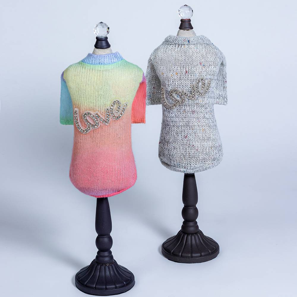 The image shows two versions of the Hello Doggie Love Dog Sweater side by side one in rainbow gradient and one in grey speckled design, both featuring the beaded love inscription