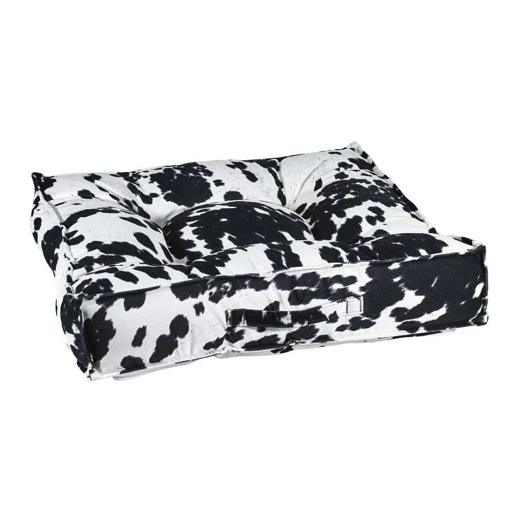Wrangler Bowsers Piazza Dog Bed in black-and-white cowhide print fabric features a plush tufted design with supportive padded sides